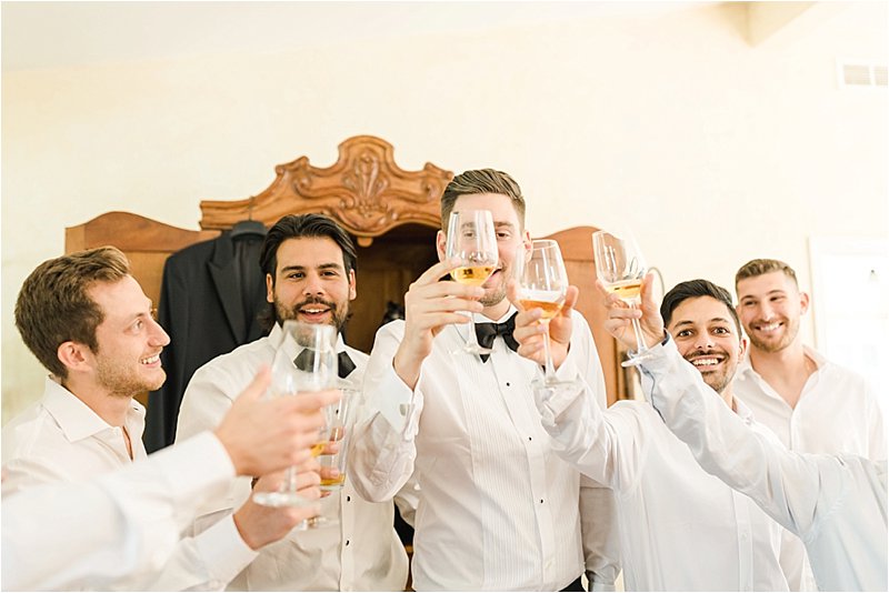 Groomsmen share a toast while getting ready.