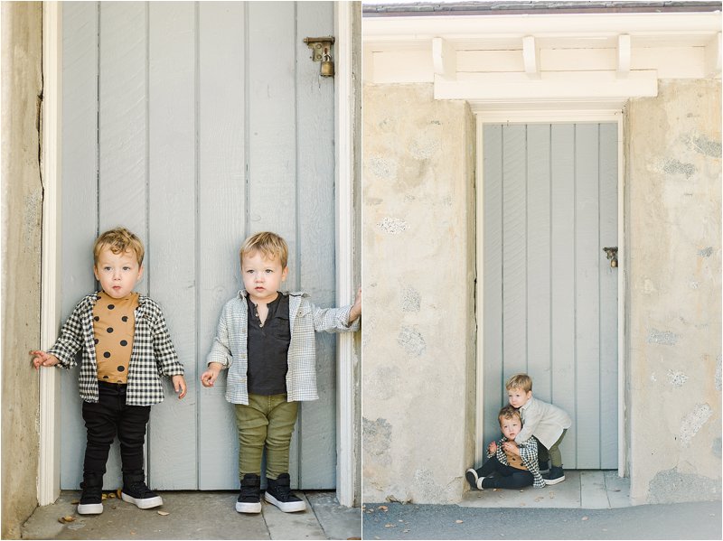 Image on the left shows 2 year old twin boys standing in front of grey-blue door.  Image on the right shows one twin sitting on the ground in front of a grey-blue door while the other twin tries to give him a hug.