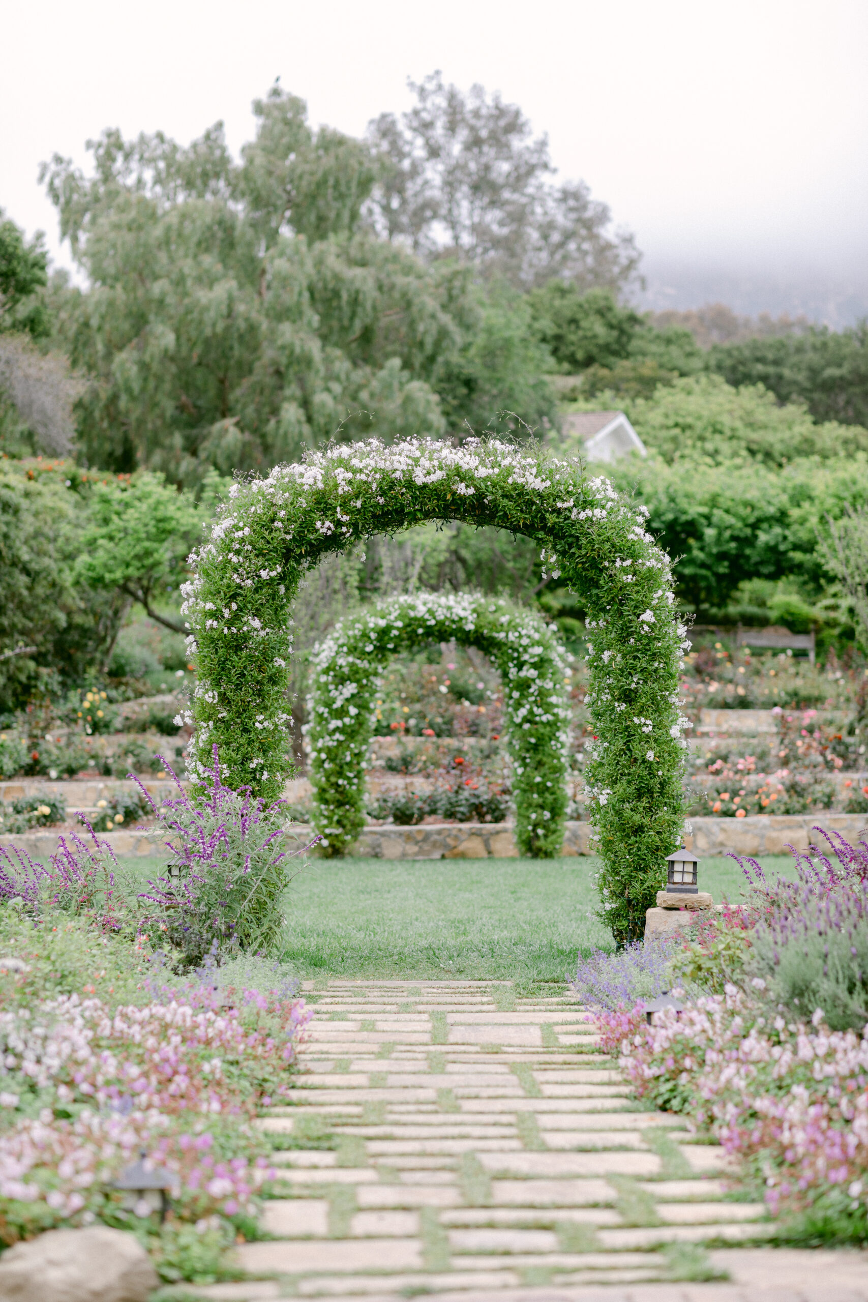 Beautiful garden setting with 2 archways covered in lush greenery for this intimate San Ysidro Ranch micro wedding.