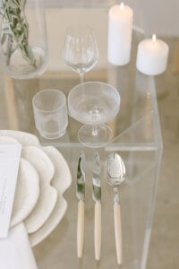 This image features a close-up shot of the tablescape flatware and fluted glassware.