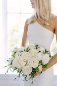 Detail photo of blonde bride holding an all white bouquet.