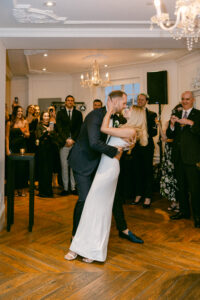 Bride and groom share a kiss as he dips her during their first dance.