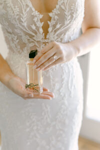 Detail photo of bride holding her Yves St Laurent wedding day perfume.