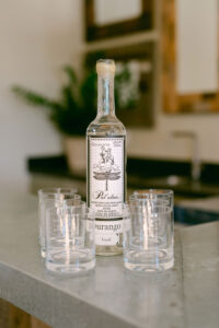 Detail photo of tequila bottle and glasses in preparation for a toast with the groomsmen.