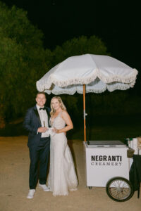 Bride and Groom pose for a photo in front of the Negranti Creamery ice cream cart which was a fun late night surprise for their guests.