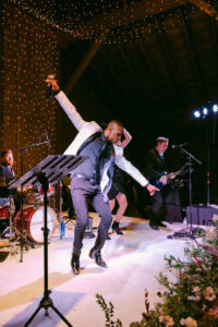 Band singer doubles as an entertainer as he dances and gets the crowd excited to keep celebrating the newlyweds.