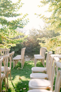 Detail photo showing the beautiful light wood cross back chairs at this beautiful lakeside wedding ceremony at Greengate Ranch in San Luis Obispo.