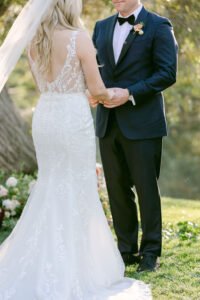 Bride and groom hold hands during their wedding ceremony as they share their vows with each other.