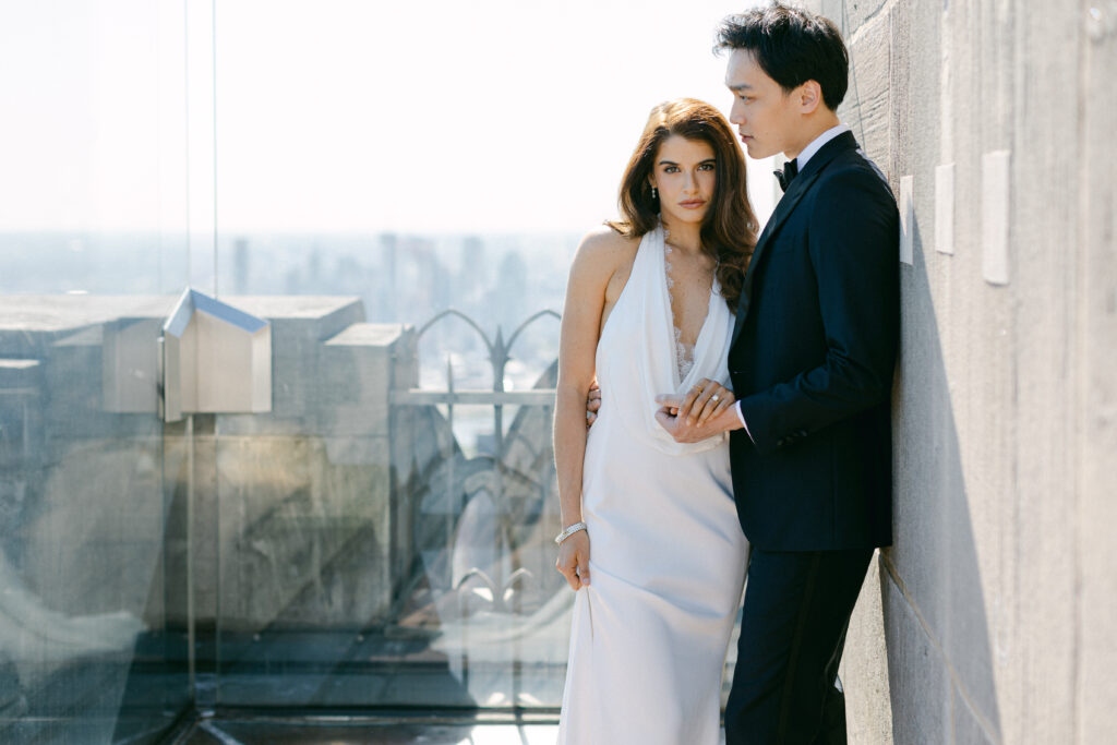 Brunette, Brazillian Bride and Asian Groom pose for a photo following their intimate elopement at Top of the Rock NYC