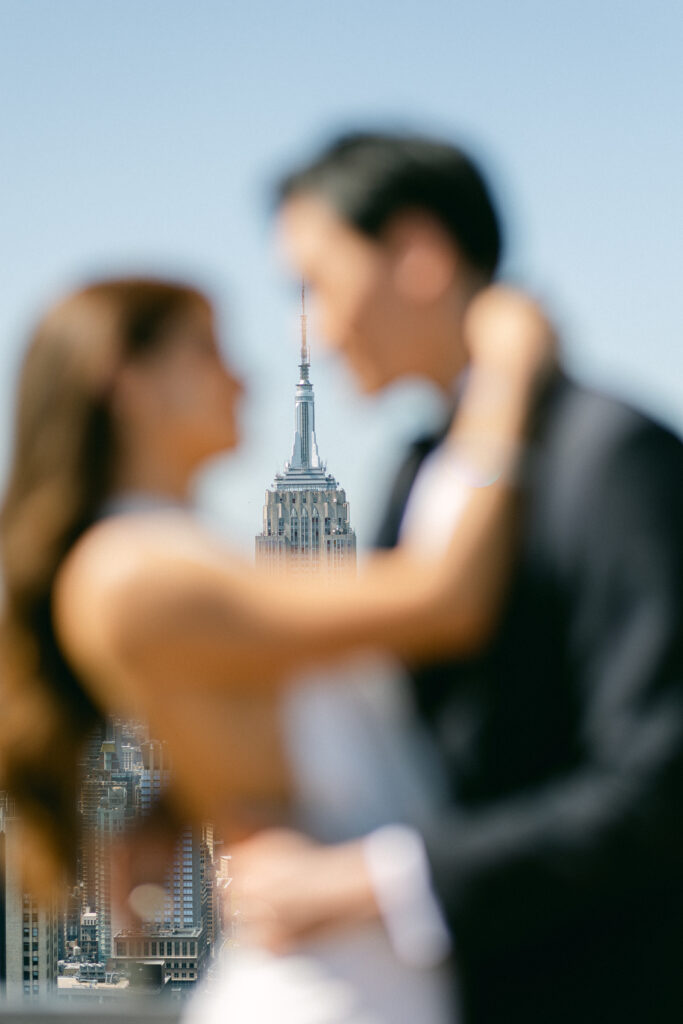 Artistic shot with bride and groom out of focus and the Empire State building in focus