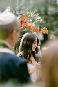 Stunning bridal portrait looking over the shoulders of her in-laws as she shares her wedding vows with her husband to be.