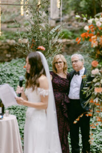 Bride's parents look adoringly at their daughter as she shares her vows with her husband to be during their Jewish wedding ceremony at Calamigos Ranch.