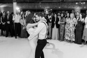 Black and white photo of bride and groom embracing and gazing into each other's eyes during their first dance.