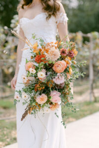 Bride holds her vibrant fall toned bridal bouquet.