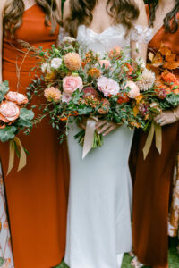 Rust colored, fall themed bridal party dresses and bouquets.