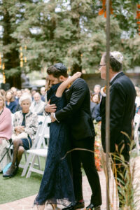 Groom embraces his mother after his parents walked him down the aisle for his wedding.