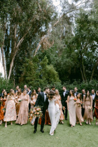 Bride and groom take a stroll across the lawn with their bridal party.