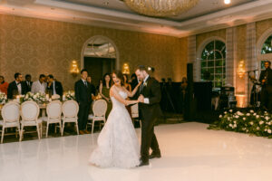 Bride smiles over her shoulder as she and her groom share their first dance.
