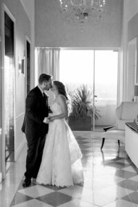 Bride and groom sneak a romantic kiss as they wait for the elevator to take them to their wedding reception at the Four Seasons Beverly Hills.