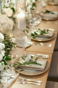 Detail photo of the reception tablescapes. Each plate had a custom menu and single white flower.