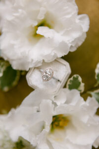 Stunning flatlay photo of oval engagement ring with halo created by Rahaminov Diamonds, photographed at the Four Seasons Beverly Hills by SoCal wedding photographer Tiffany J Photography.