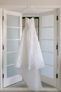 Strapless, lace Monique Lhuillier wedding gown hanging in bridal suite at Four Seasons Beverly Hills. Photographed by SoCal wedding photographer Tiffany J Photography.