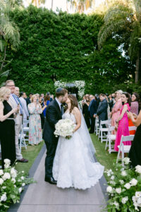 Bride and Groom share a kiss during their recessional following their wedding ceremony at the Four Seasons Beverly Hills.