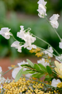 A floral arrangement featuring a mix of white and yellow flowers arranged elegantly.