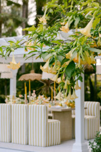A white table surrounded by yellow striped chairs, creating a bright and inviting dining area.