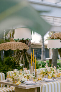 A white table surrounded by yellow striped chairs, creating a bright and inviting dining area.