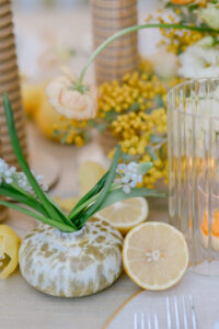 A table adorned with a vase of vibrant yellow flowers and decorative lemon slices.