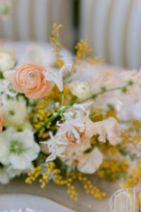 A table adorned with a vase of white and orange flowers, creating a vibrant and elegant centerpiece.