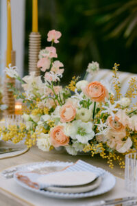 A table adorned with a vibrant arrangement of various yellow, peach and white spring flowers in full bloom.