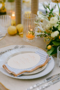 A table setting featuring white and yellow flowers alongside fresh lemons, creating a vibrant and inviting atmosphere.