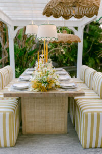 A table surrounded by white and yellow striped chairs, creating a vibrant and inviting dining area.